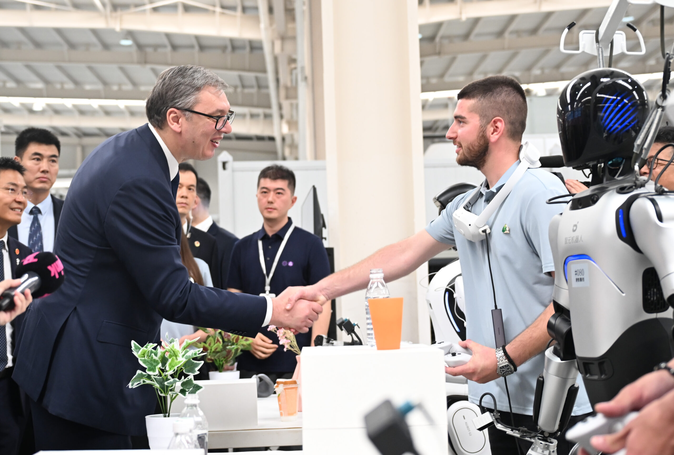 Le président serbe Aleksandar Vucic s'entretient avec un jeune Serbe lors de sa visite au groupe Minth à Jiaxing, dans la province du Zhejiang (est de la Chine), le 27 mai 2026. /IC