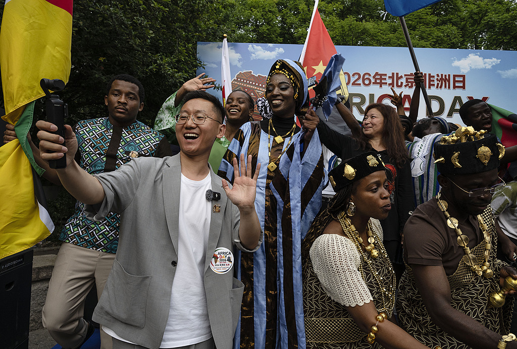 Un visiteur chinois filme une vidéo tandis que des ressortissants de pays africains participent à l'événement de la Journée de l'Afrique à Pékin, en Chine, le 23 mai 2026. /VCG