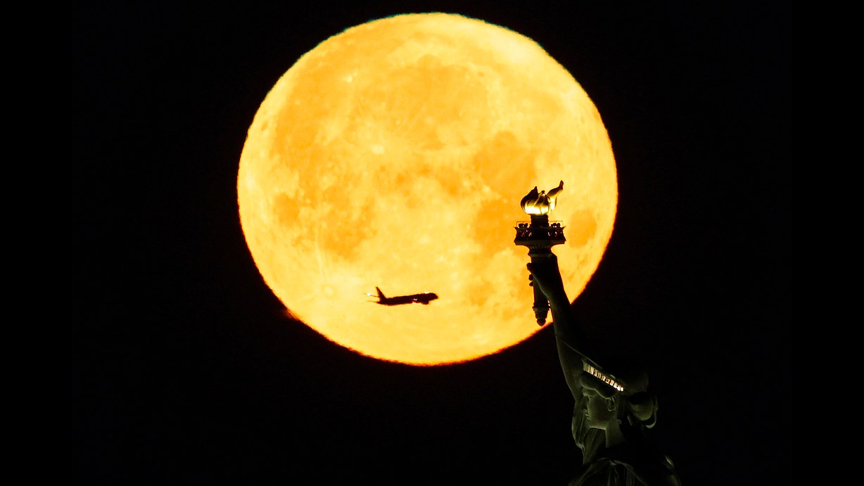 Une rare lune bleue se couche derrière la Statue de la Liberté, New York, États-Unis, le 31 mai 2026. /VCG