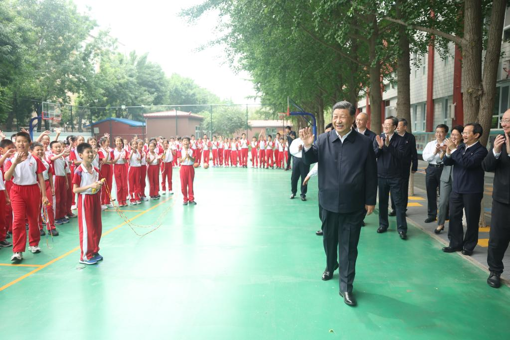 Le président chinois Xi Jinping, également secrétaire général du Comité central du Parti communiste chinois et président de la Commission militaire centrale, salue les élèves sur le terrain de basket de l'école Yuying de Pékin, à Pékin, le 31 mai 2023. /Xinhua