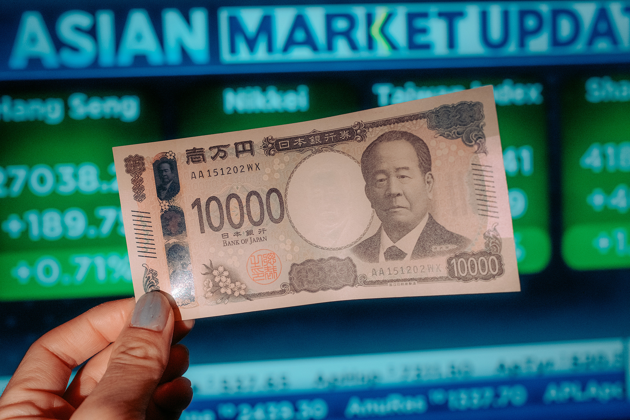 Un billet japonais de 10 000 yens devant un écran affichant les mises à jour du marché asiatique disposé à Kyoto, au Japon, le 27 janvier 2026. /VCG