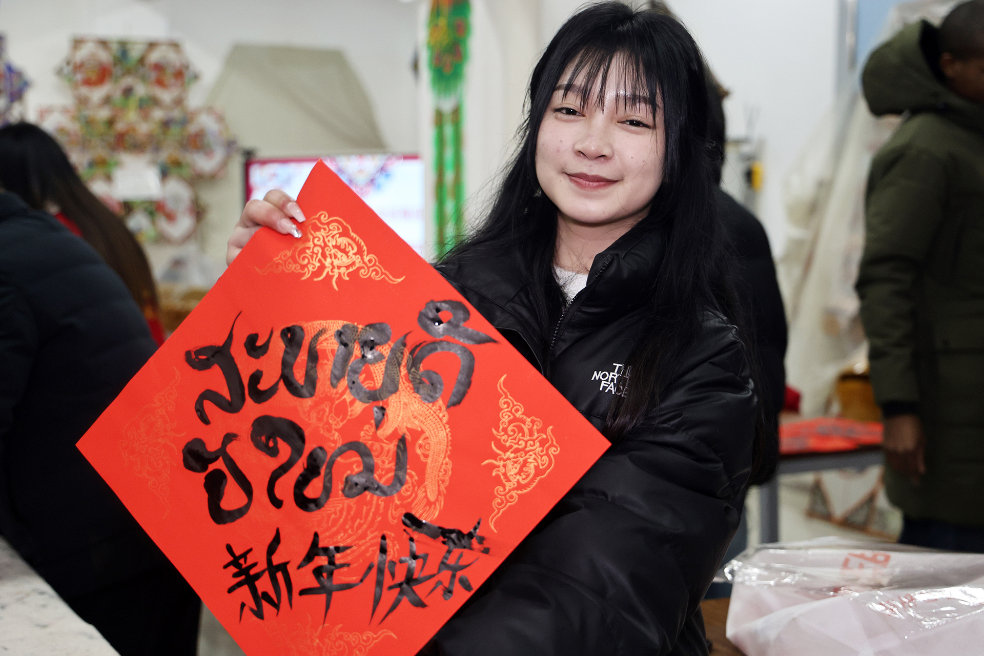 Un étudiant laotien montre un morceau de papier rouge portant la phrase 