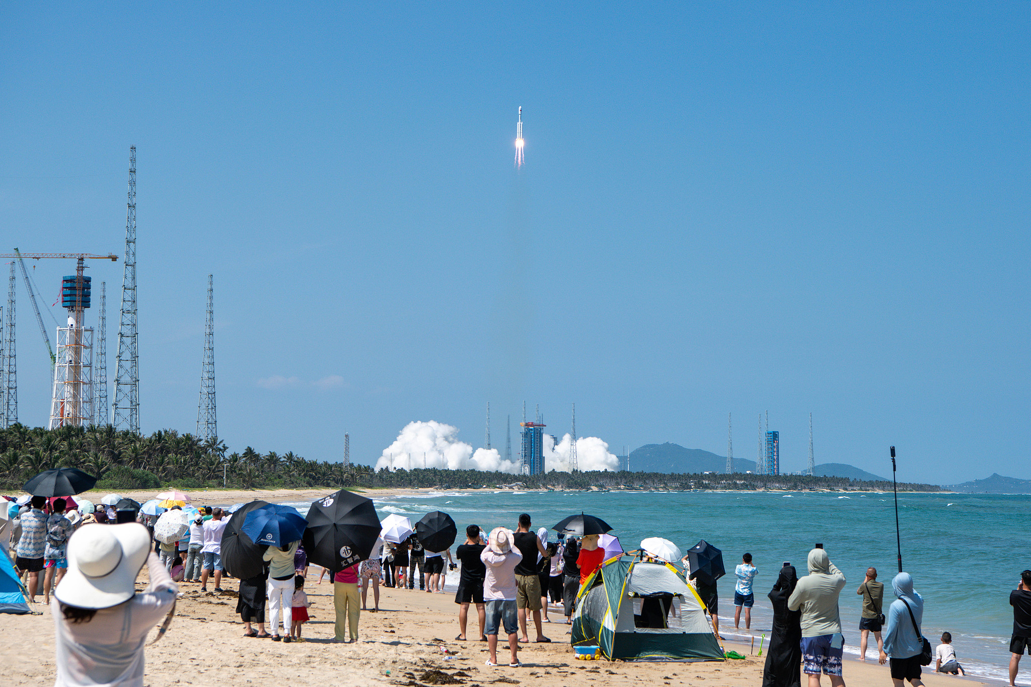 Des gens regardent le lancement d'une fusée Longue Marche-8 transportant les satellites Qianfan, dans la ville de Wenchang, province de Hainan (sud de la Chine), le 5 juin 2026. /VCG