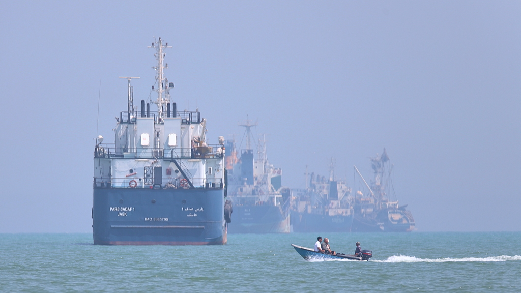 Un petit bateau à moteur croise des navires ancrés dans le détroit d'Ormuz au large de Bandar Abbas, en Iran, le 11 juin 2026. /VCG