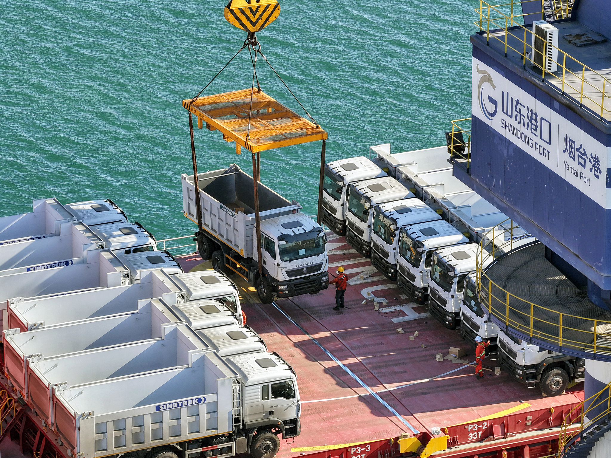 Des camions produits localement à destination de la Tanzanie sont chargés sur un paquebot Chine-Afrique au port de Yantai, dans la province du Shandong, en Chine, le 7 juin 2022. /VCG 