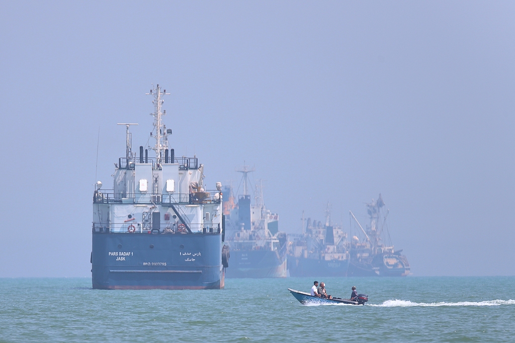 Un petit bateau à moteur croise des navires ancrés dans le détroit d'Ormuz au large de Bandar Abbas, en Iran, le 11 juin 2026. /VCG