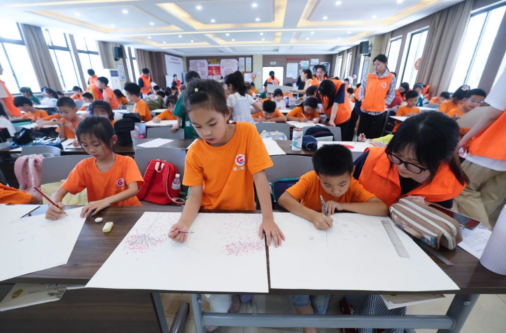 Les enfants dessinent grâce au tutorat des bénévoles de la Summer Love Classroom du centre de services de fête de masse de la communauté de Xishan. Ville de Haining, province du Zhejiang, Chine, 23 juillet 2025. /Xinhua