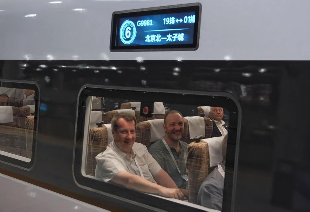 Des représentants étrangers participant au 12e Congrès mondial sur le train à grande vitesse voyagent sur la ligne à grande vitesse Pékin-Zhangjiakou, de la gare du Nord de Pékin à Taizicheng, lieu des Jeux olympiques d'hiver de Pékin 2022, le 11 juillet 2025. /VCG
