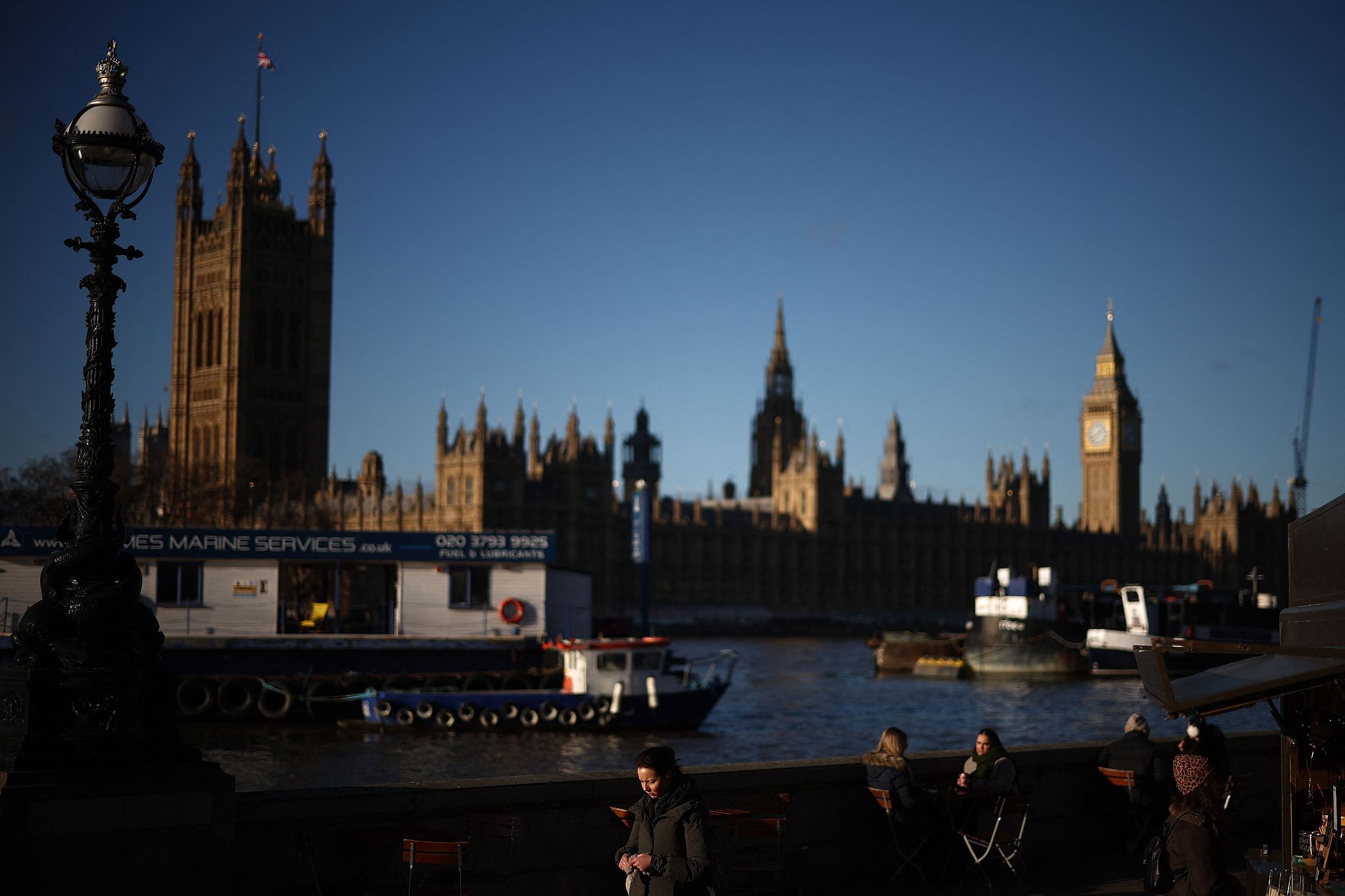 Des gens marchent sur la rive sud avec le Palais de Westminster, qui abrite le Parlement, à Londres, au Royaume-Uni, le 4 janvier 2026. /AFP