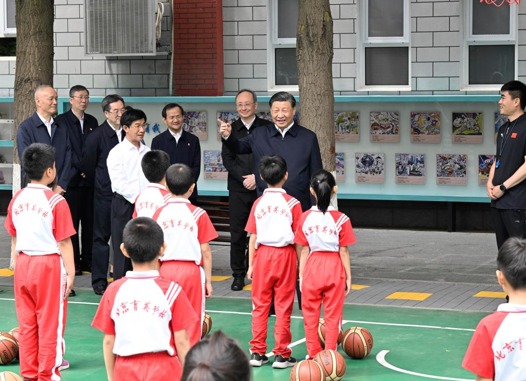 Le président chinois Xi Jinping, également secrétaire général du Comité central du Parti communiste chinois et président de la Commission militaire centrale, s'entretient avec des étudiants sur le terrain de basket de l'école Yuying de Pékin, à Pékin, le 31 mai 2023. /Xinhua