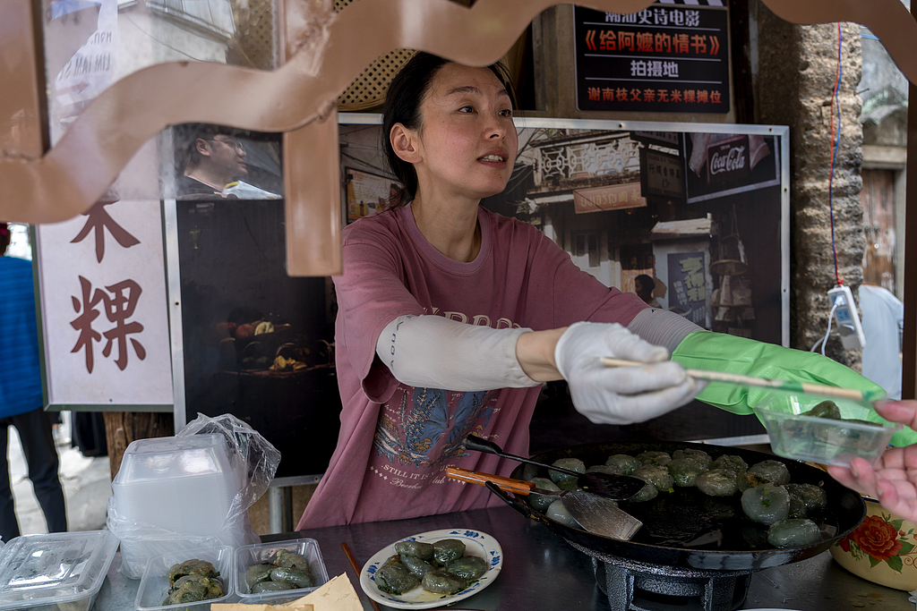 Une femme vend des plats présentés dans le film Dear You depuis un stand de nourriture reconstitué dans la ville de Mianhu, comté de Jiexi, Jieyang, province du Guangdong, le 31 mai 2026. /VCG