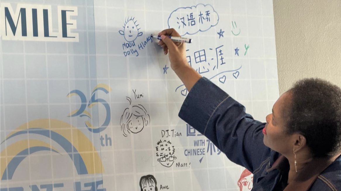 Un candidat dessine un visage souriant sur le mur d'enregistrement, le 12 juin 2026. /CMG Afrique