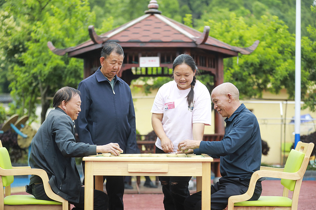 Des volontaires jouent aux échecs chinois avec des résidents âgés dans un appartement pour personnes âgées de la province du Guizhou, en Chine, le 2 juin 2026. /VCG