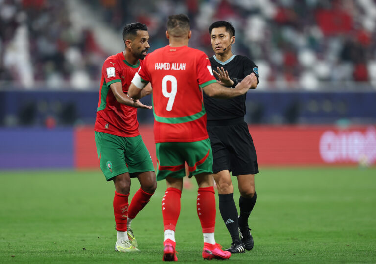 L'arbitre Ma Ning s'adresse au capitaine Abderrazzak Hamed Allah (#9) lors du match du Maroc contre les Comores dans le groupe B de la Coupe arabe de la FIFA 2025 au stade international de Khalifa à Doha, Qatar, le 2 décembre 2025. /VCG