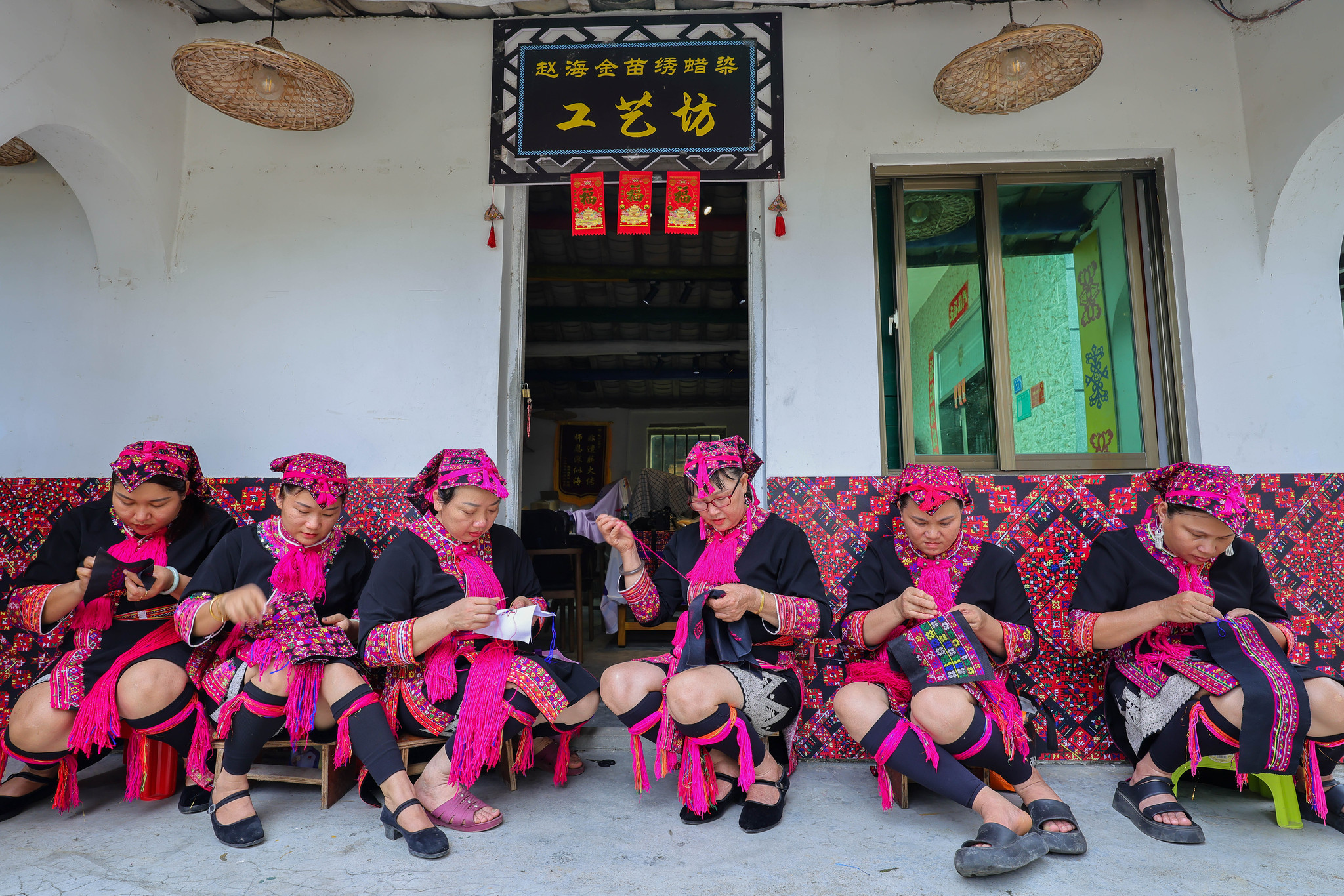 L'héritier Zhao Haijin, troisième en partant de la droite, et des apprenants en broderie Miao sont vus à l'atelier de Zhao dans la province de Hainan le 1er juillet 2026. /VCG
