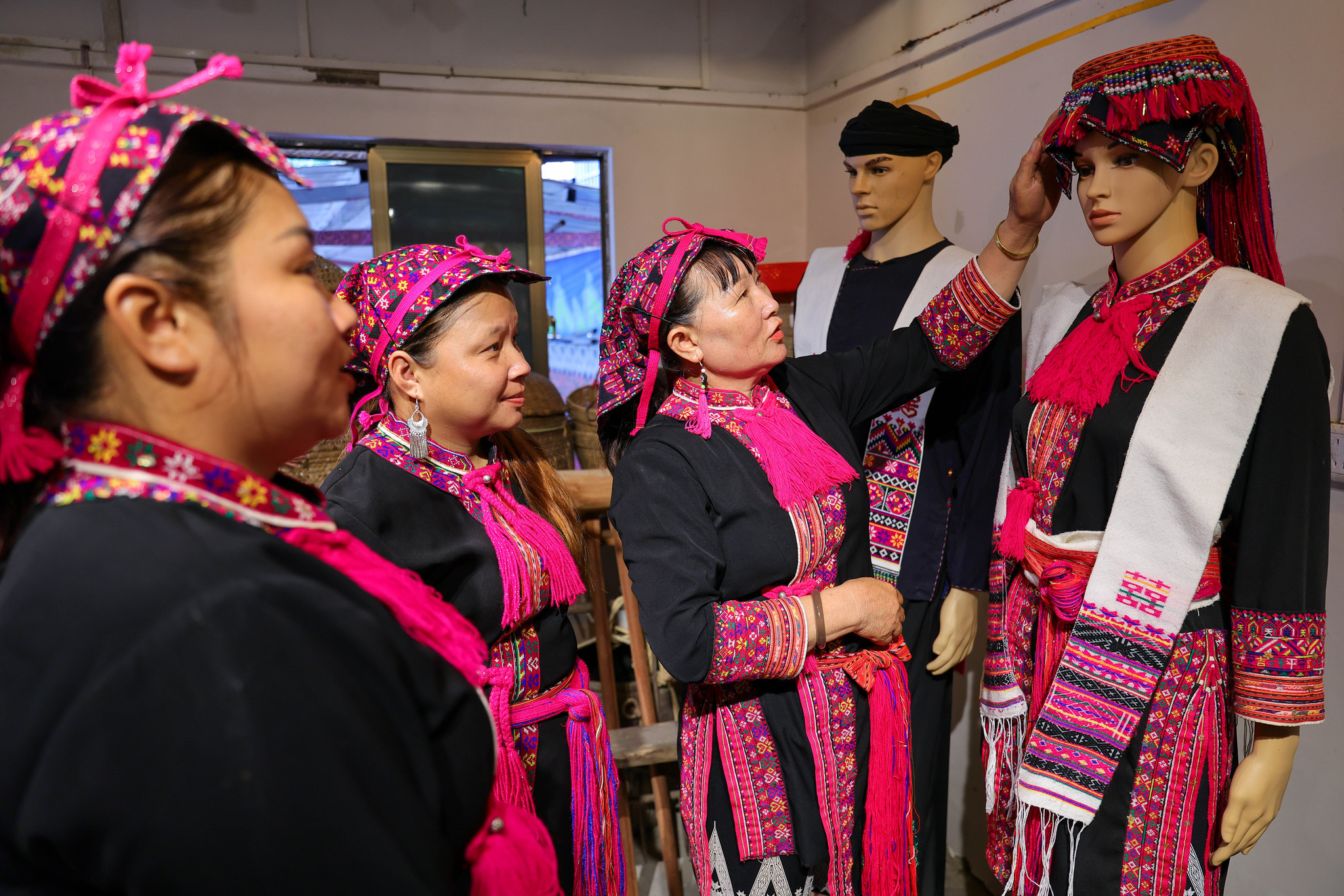 L'héritière Zhao Haijin présente des pièces de broderie Miao aux apprenants lors de son atelier dans la province de Hainan le 1er juillet 2026. /VCG