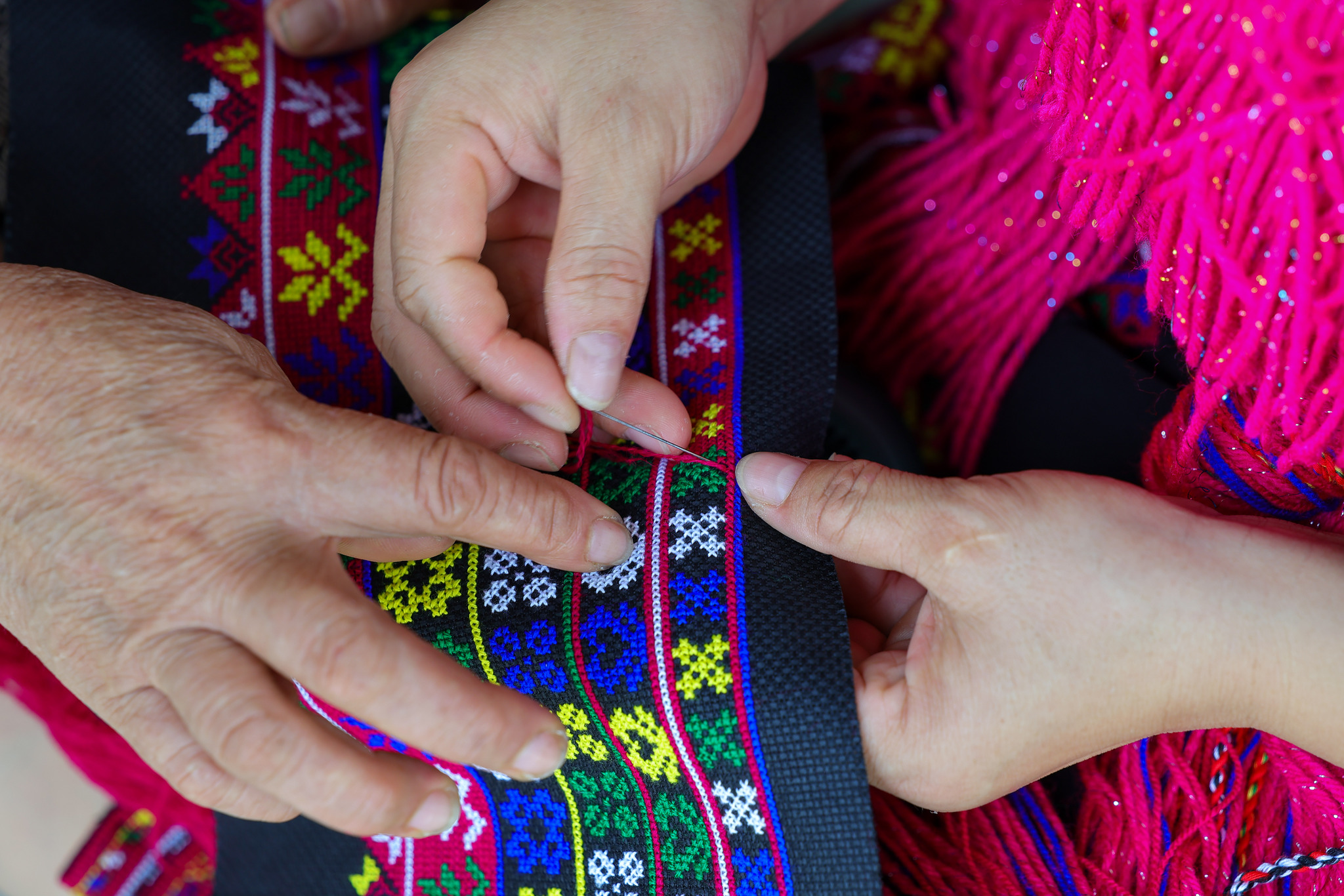 L'héritière Zhao Haijin guide les apprenants en broderie Miao dans son atelier de la province de Hainan le 1er juillet 2026. /VCG