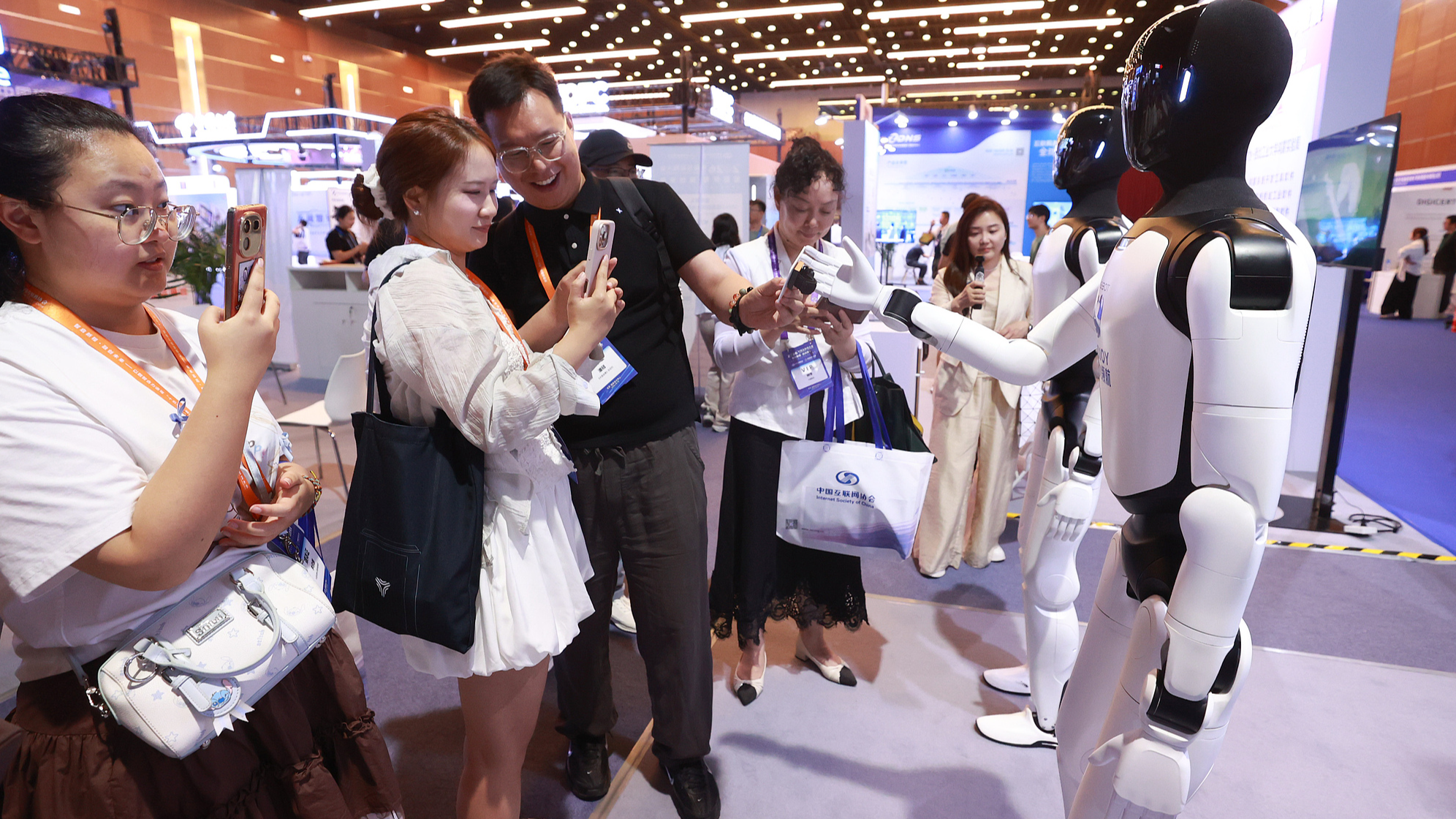 Les participants à la 25e Conférence Internet de Chine interagissent avec des robots humanoïdes au Centre national des congrès de Chine à Pékin, capitale chinoise, le 8 juillet 2026. /VCG