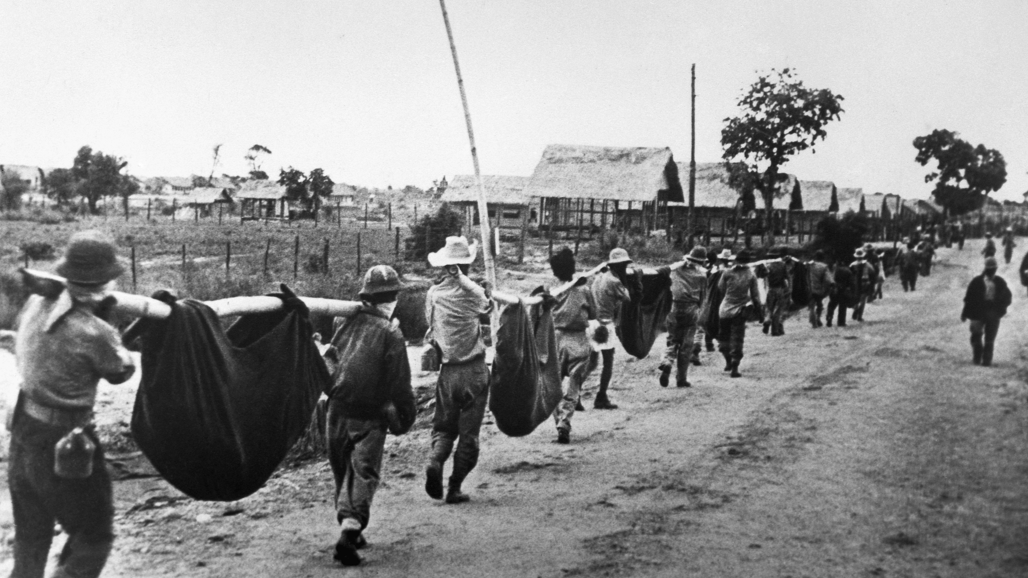 Les prisonniers américains utilisent des civières improvisées pour transporter leurs camarades qui, faute de nourriture ou d'eau lors de la marche depuis Bataan, sont tombés sur la route, aux Philippines, mai 1942. /VCG