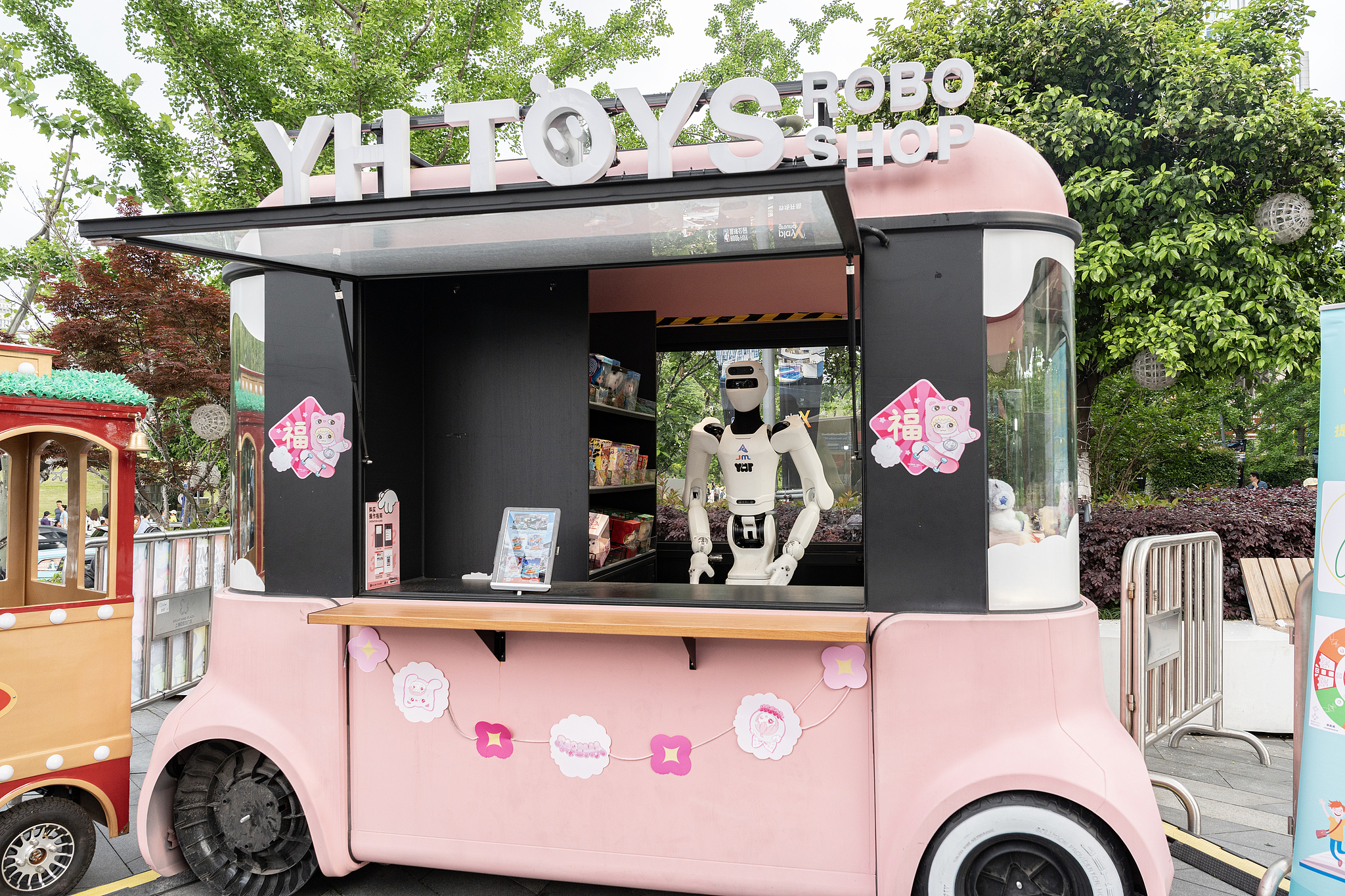 Le robot de service humanoïde GALBOT monte la garde devant une vitrine de vente au détail intelligente sans pilote à Baiyulan Plaza, Shanghai, Chine, le 4 mai 2026. /VCG