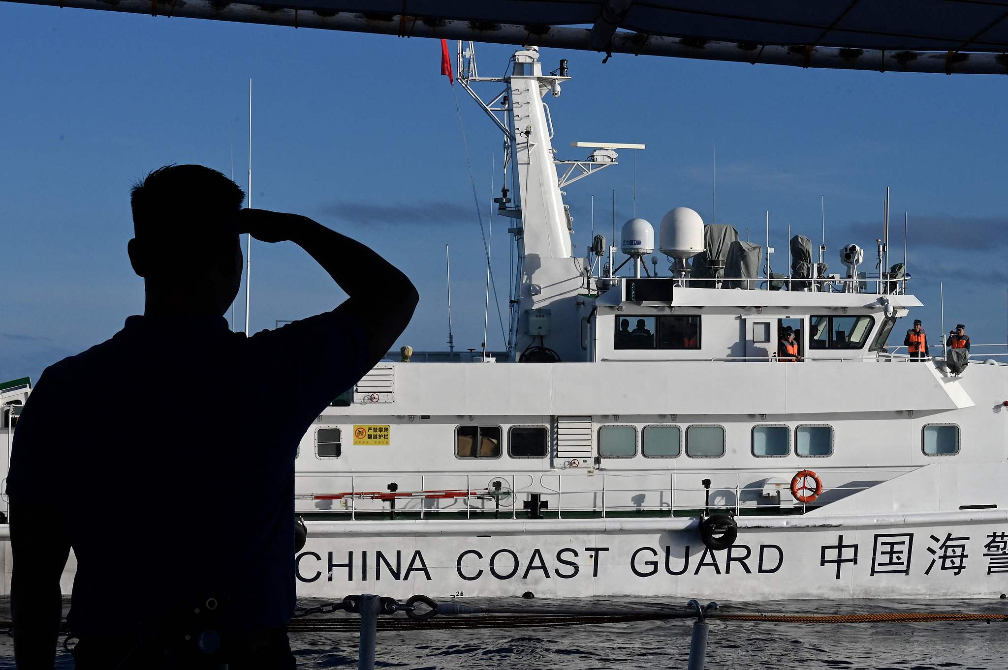 Un homme regarde un navire des garde-côtes chinois dans la mer de Chine méridionale, le 10 novembre 2023. /VCG