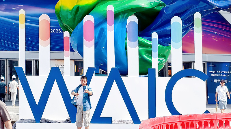 Des gens prennent un selfie devant le logo WAIC, Shanghai, le 14 juillet 2026. /CFP