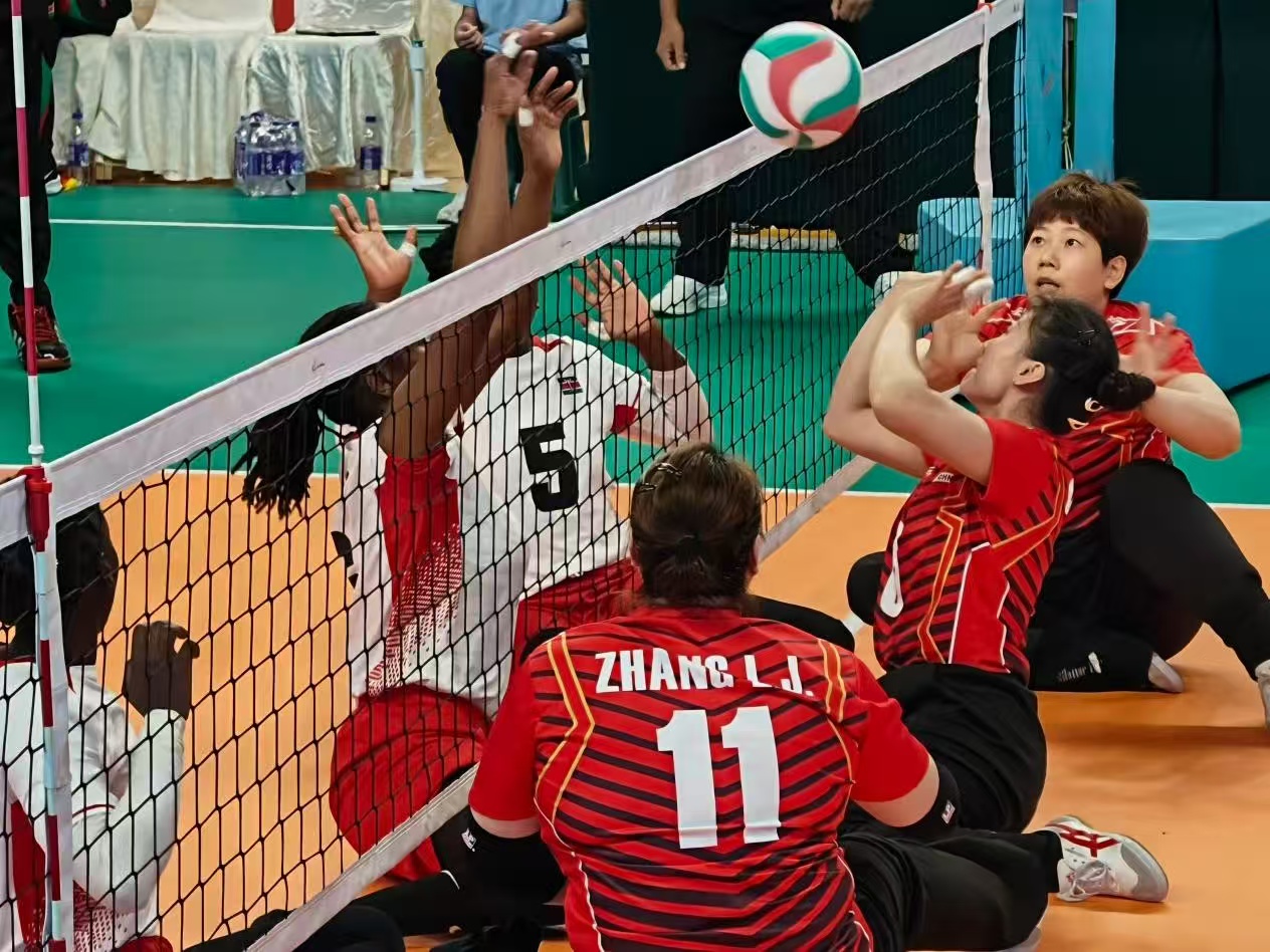 Des joueurs de volley-ball assis s'affrontent avec leurs hanches en contact avec le sol à la base d'entraînement de goalball de Chine à Hangzhou, dans la province du Zhejiang. /Luo Xiao, GCM