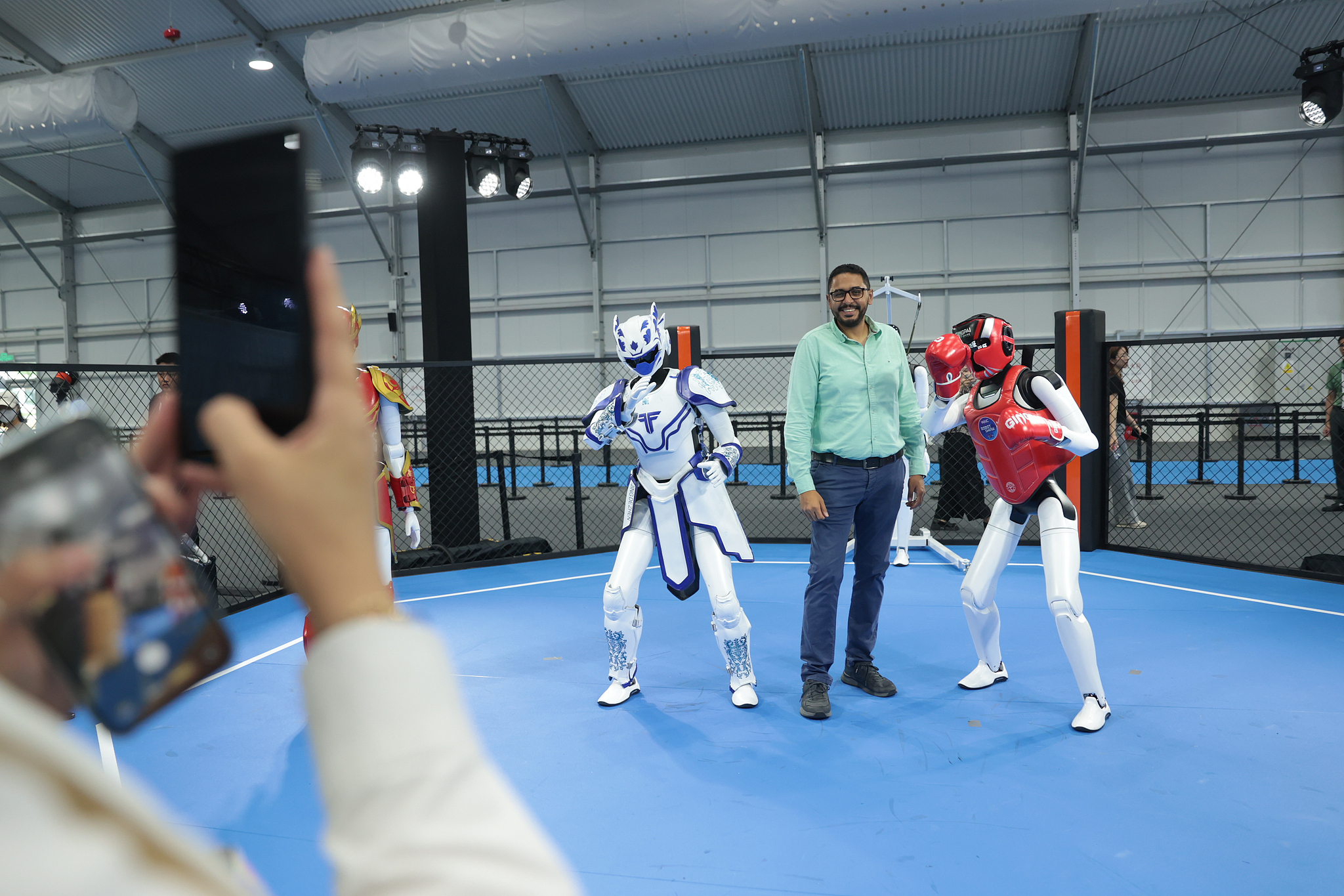 Un visiteur étranger pose pour une photo avec un robot lors du WAIC 2026 à Shanghai, dans l'est de la Chine, le 19 juillet 2026. /VCG