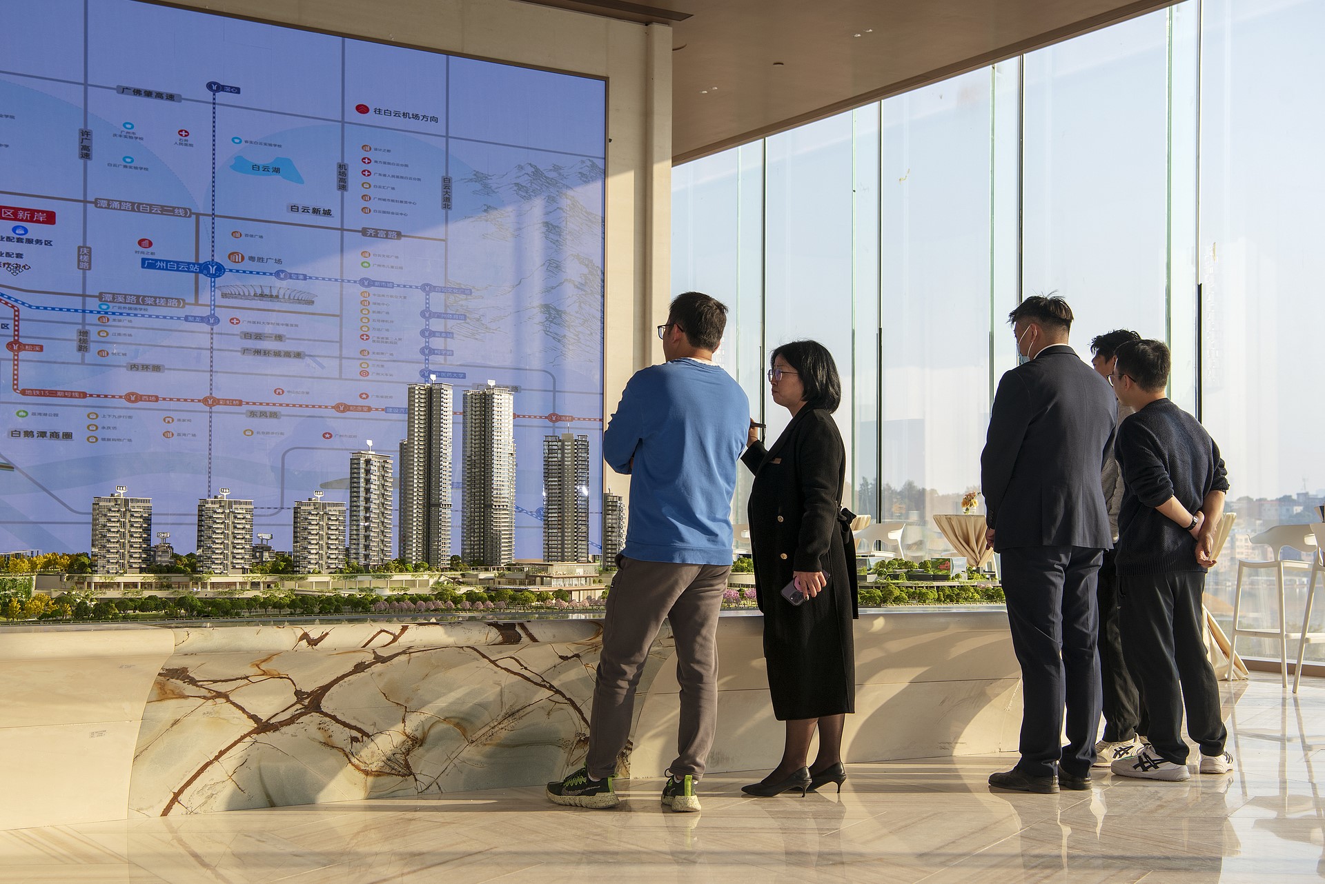Des acheteurs de maison consultent des représentants commerciaux dans une salle d'exposition immobilière à Guangzhou, province du Guangdong, Chine, le 28 décembre 2025. /VCG