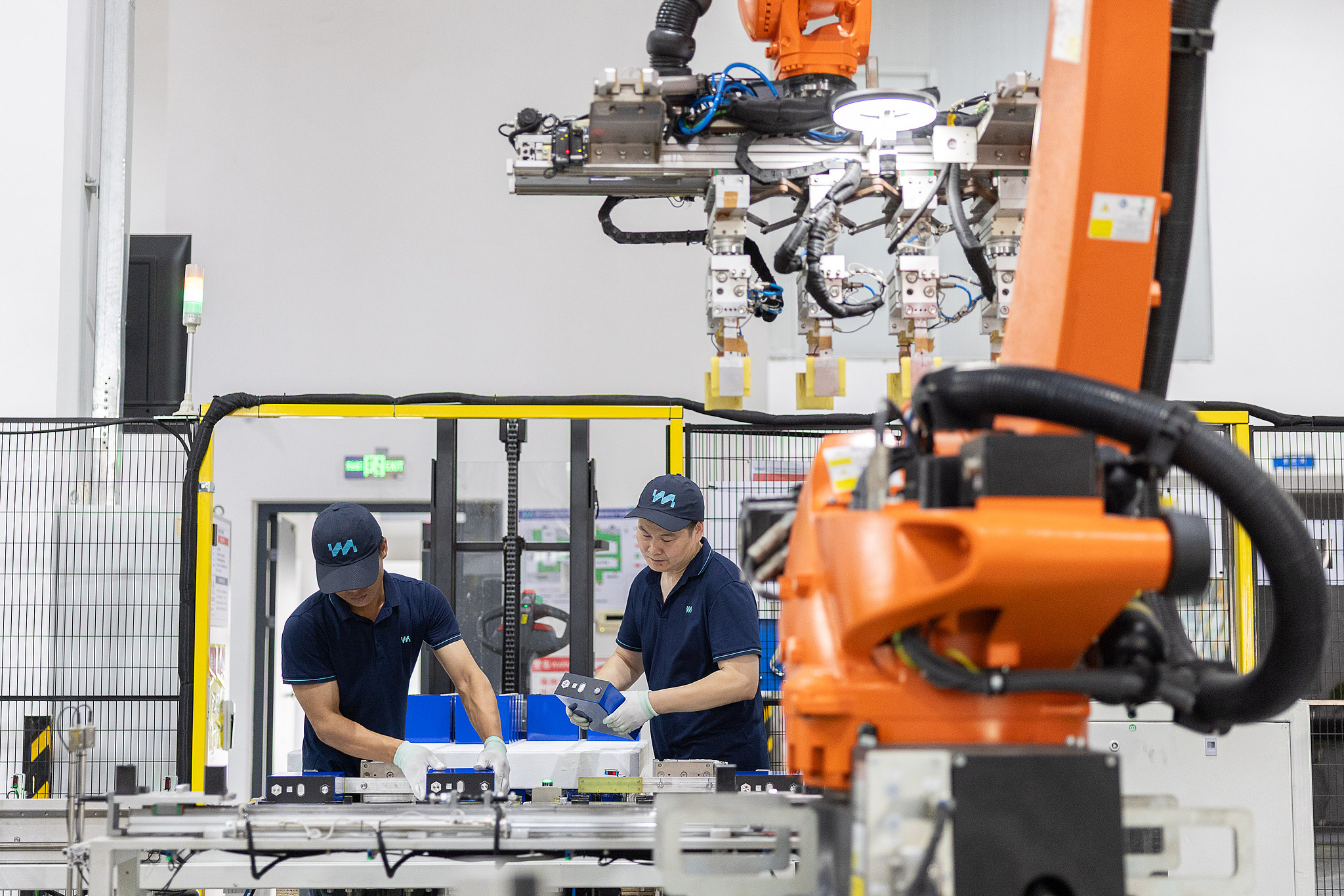 Des ouvriers produisent des batteries à semi-conducteurs tandis que des robots industriels fonctionnent sur une chaîne de production automatisée à Huzhou, province du Zhejiang, Chine, le 8 juillet 2026. /VCG