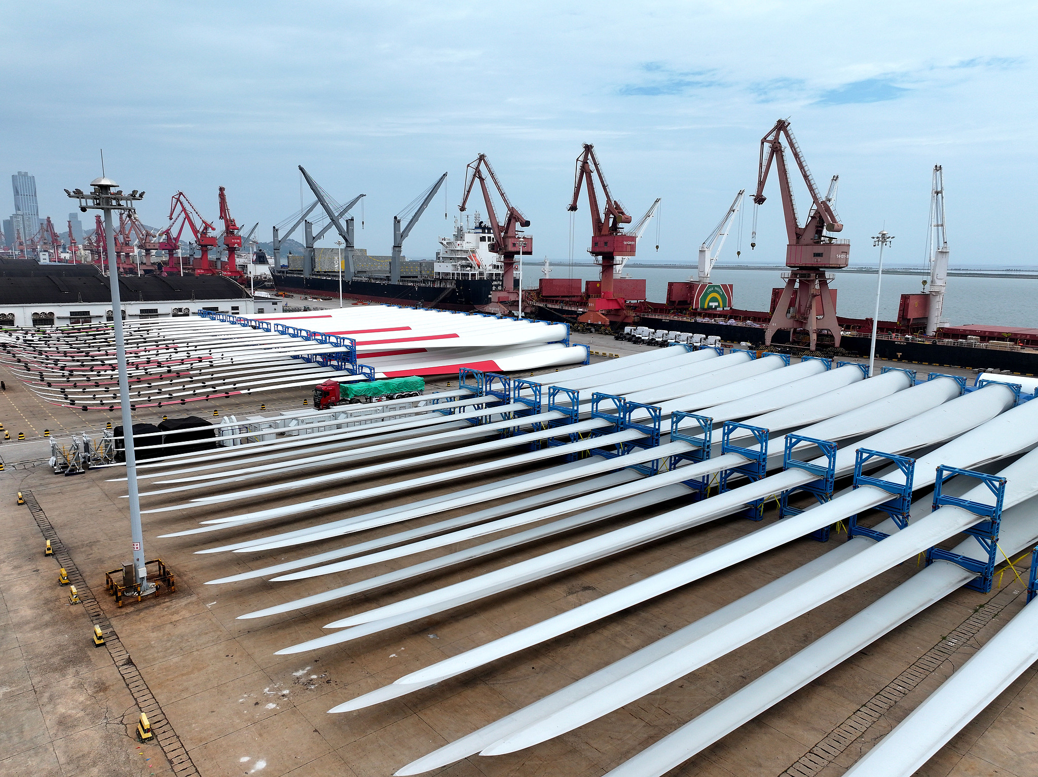 Des éoliennes fabriquées en Chine attendent d'être chargées pour l'exportation dans un port de Lianyungang, province du Jiangsu, Chine, le 22 juillet 2026. /VCG
