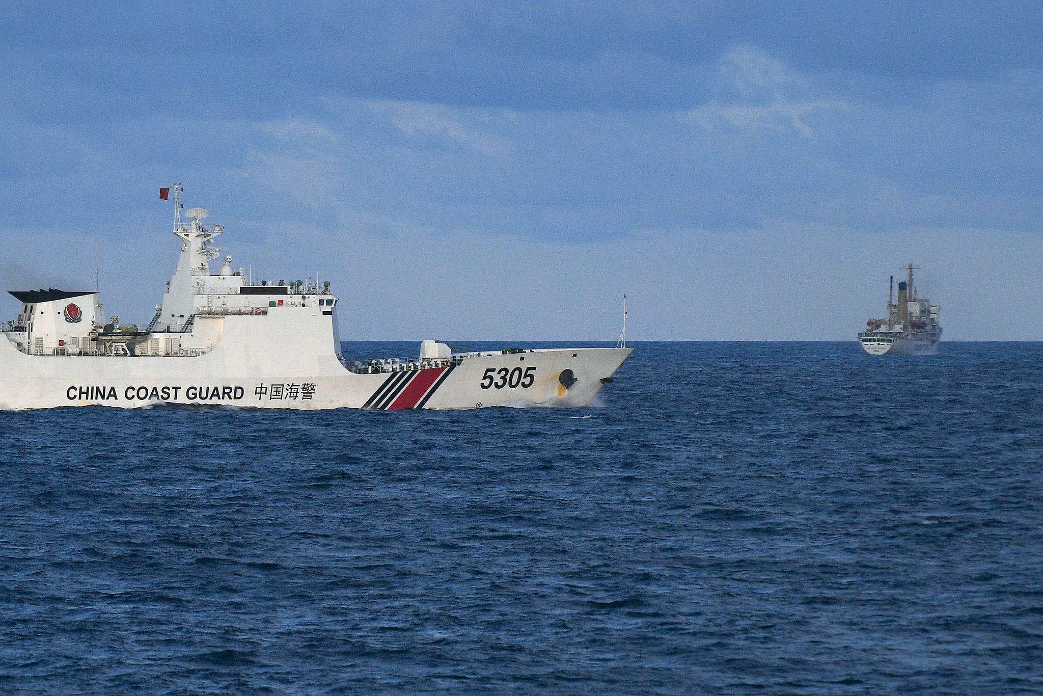 Un navire de la Garde côtière chinoise (à gauche) navigue près d'un navire philippin dans la mer de Chine méridionale, le 10 décembre 2023. /VCG
