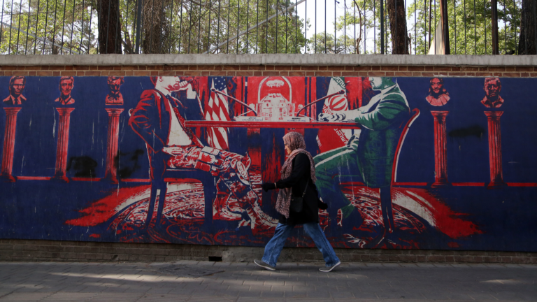 Une femme passe devant une fresque murale représentant les pourparlers américano-iraniens dans une rue de Téhéran, Iran, le 18 juin 2026. /VCG