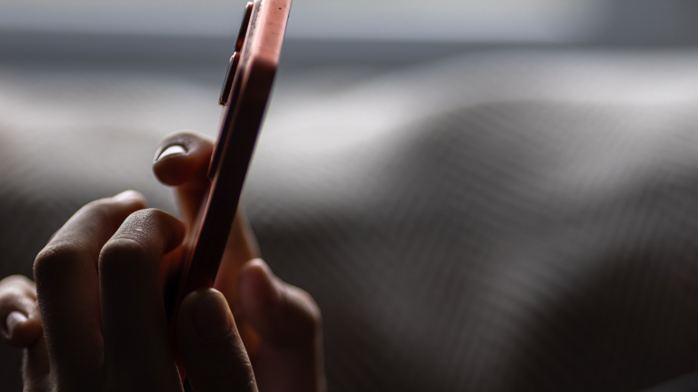 Une personne utilise un smartphone dans un environnement faiblement éclairé. /VCG
