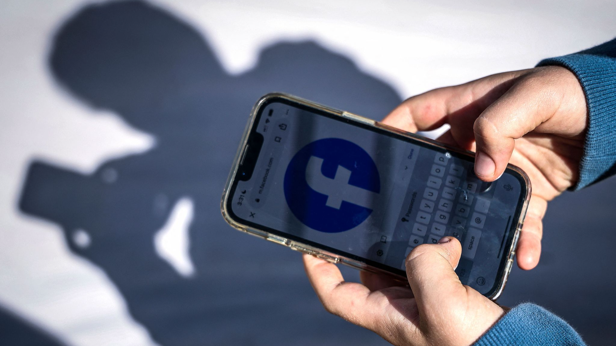 Cette photo prise le 24 octobre 2025 montre un garçon de 14 ans posant chez lui près de Gosford alors qu'il consulte les réseaux sociaux sur son téléphone portable. /VCG