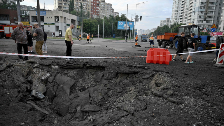 Des gens se tiennent près d'un cratère suite à des frappes de missiles russes sur la capitale ukrainienne de Kiev, le 11 juillet 2026. /VCG