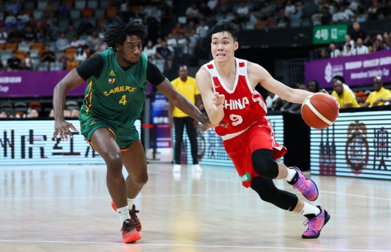 L'arrière chinois Pang Zhenglin (à droite) affronte l'arrière camerounais Valentin Lele lors d'un match de basket-ball lors de la Coupe internationale de solidarité à Haikou, dans la province chinoise de Hainan (sud), le 27 juillet 2026. /Xinhua