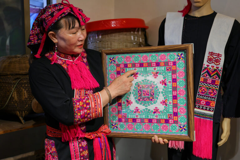 L'héritière Zhao Haijin montre sa pièce de broderie Miao, qui a été présentée lors de la Semaine internationale de la mode de Chine 2020, dans la province de Hainan, le 1er juillet 2026. /VCG