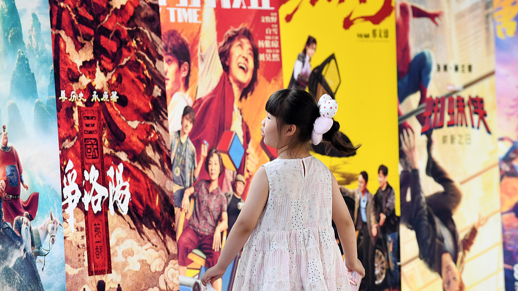 Une jeune fille passe devant des affiches de films exposées dans un cinéma de Zunyi, dans la province du Guizhou (sud-ouest de la Chine), le 12 juillet 2026. /VCG