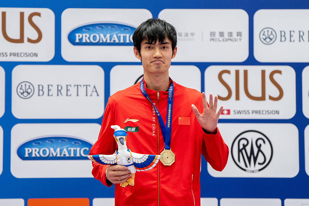 Le Chinois Sheng Lihao célèbre avec sa médaille d'or après avoir remporté la finale masculine de carabine à air comprimé 10 m lors de la Coupe du monde ISSF à Hangzhou, en Chine, le 22 juillet 2026. /VCG