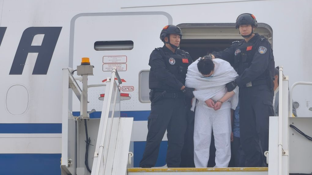 Le principal suspect dans une affaire d'enlèvement et de meurtre visant des citoyens chinois aux Philippines est escorté par la police à l'aéroport international de Pékin, en Chine, le 20 juillet 2026. /Xinhua