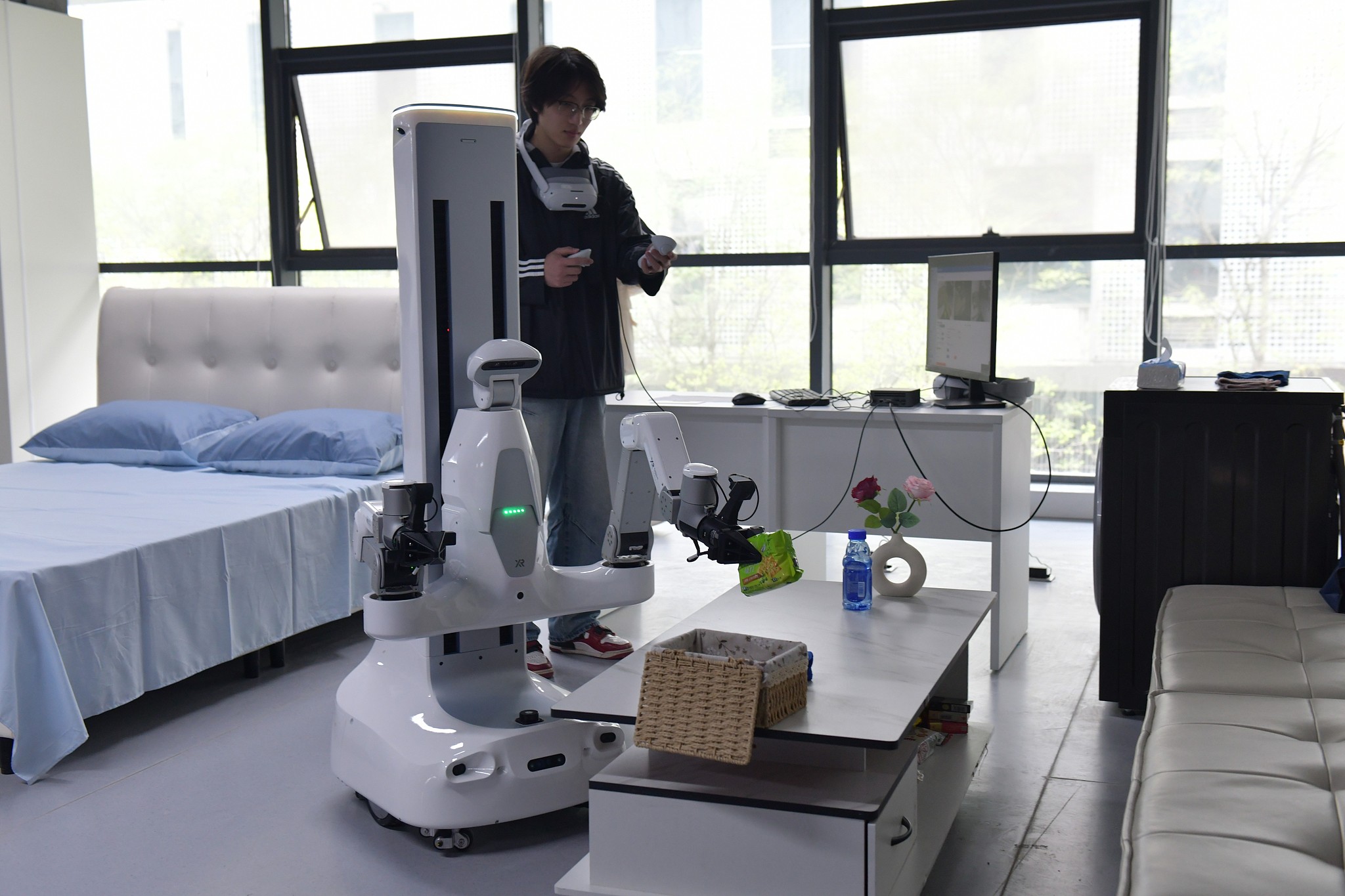 Des collecteurs de données entraînent des robots à nettoyer un salon, Hefei, province de l'Anhui, Chine, 13 avril 2026. /VCG