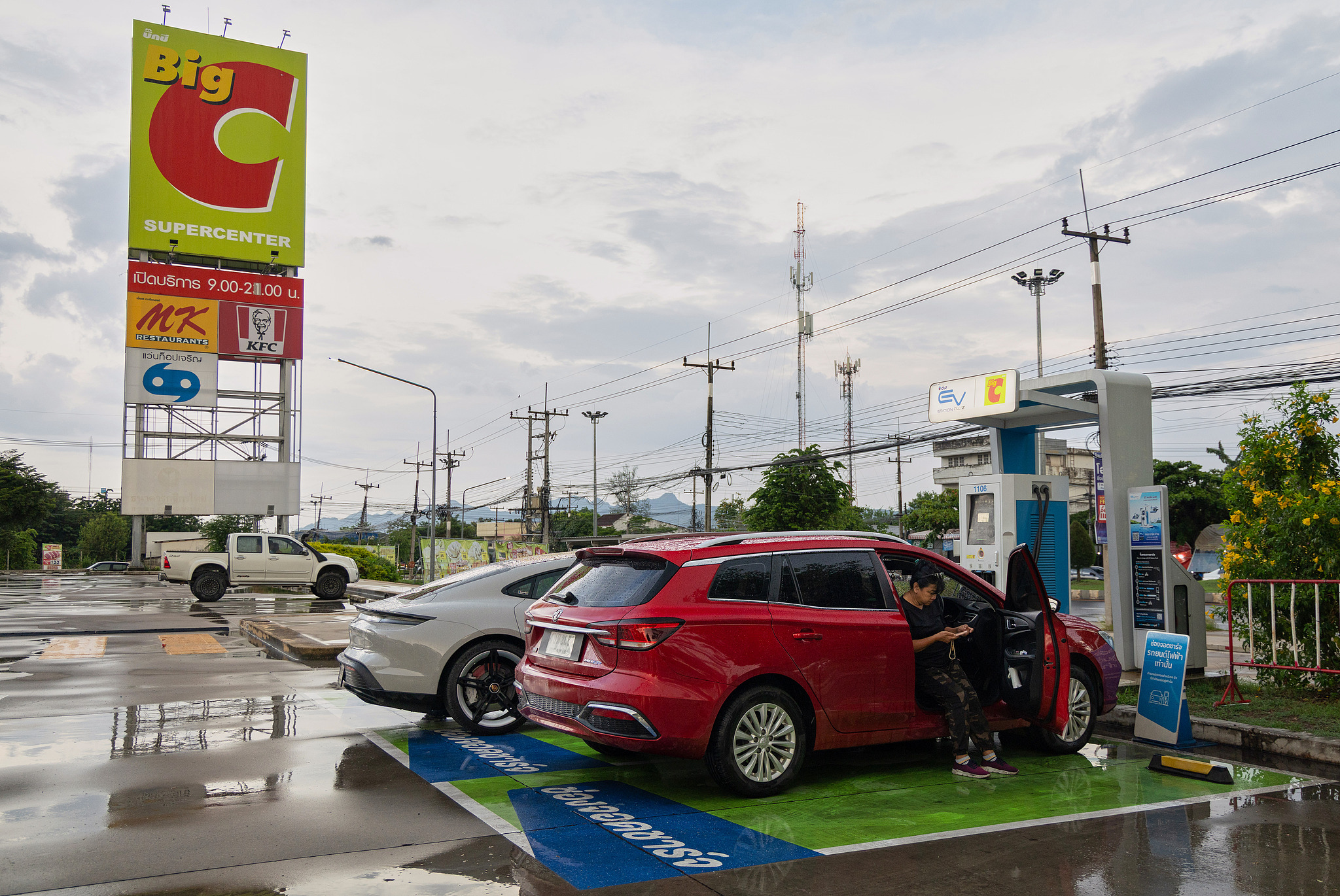 Une Thaïlandaise attend que son véhicule électrique de fabrication chinoise se charge dans une station-service à Kanchanaburi, en Thaïlande, le 30 mai 2026. /VCG