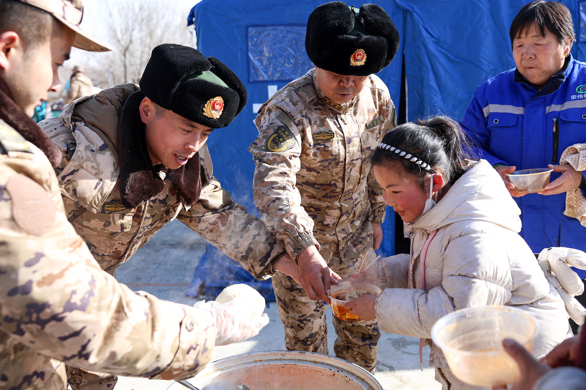 Les habitants touchés par un tremblement de terre dans la préfecture autonome Hui de Linxia, province du Gansu, reçoivent de la nourriture chaude le 21 décembre 2023. /VCG