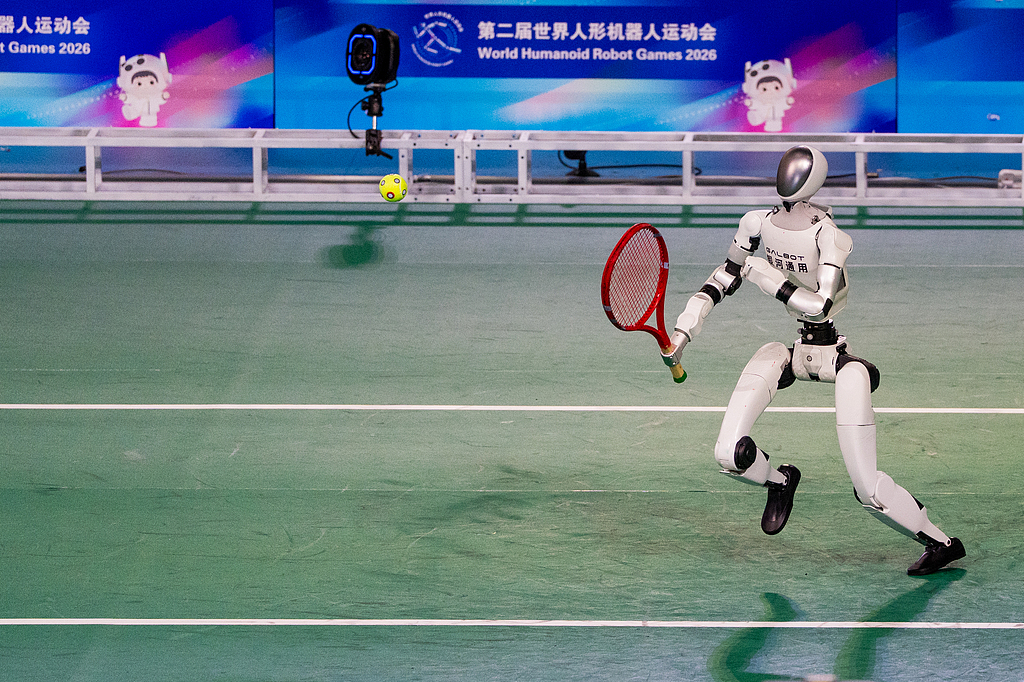 Un robot humanoïde joue au tennis lors de la cérémonie d'ouverture des deuxièmes Jeux mondiaux du robot humanoïde au National Speed Skating Oval de Pékin, en Chine, le 22 août 2026. /VCG