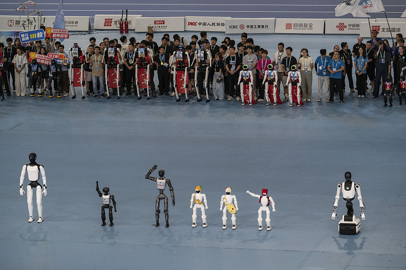 Des robots humanoïdes saluent lors de la cérémonie de clôture des 2e Jeux mondiaux de robots à l'Anneau national de patinage de vitesse à Pékin, en Chine, en août 2026. /VCG