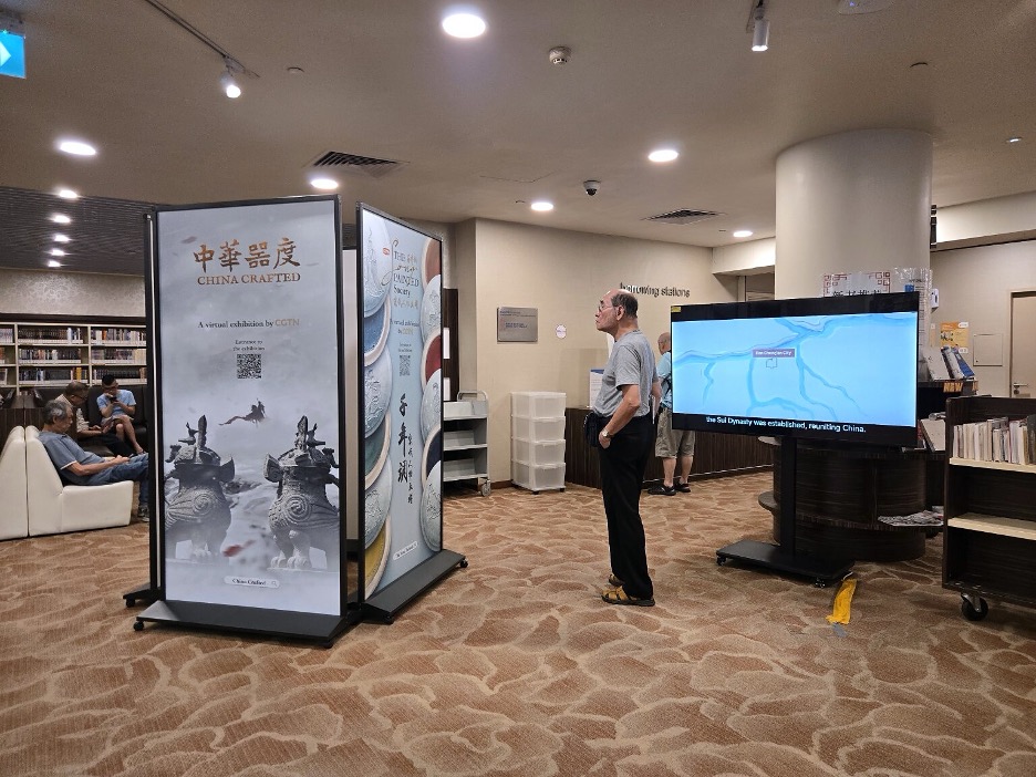 Un visiteur s'arrête devant l'exposition China Crafted à la bibliothèque Chinatown de Singapour. /CGTN