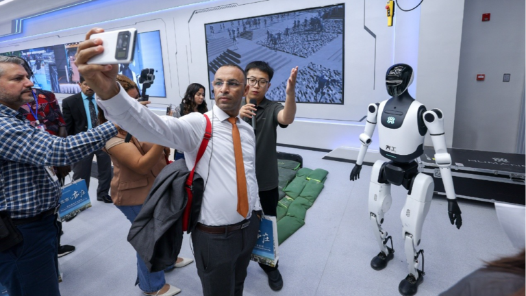 Un journaliste prend un selfie avec le robot humanoïde Tiangong à Pékin, en Chine, le 29 septembre 2025. /CFP