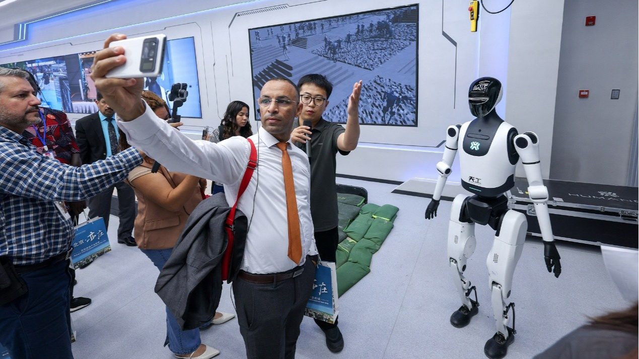 Un journaliste prend un selfie avec le robot humanoïde Tiangong à Pékin, en Chine, le 29 septembre 2025. /CFP