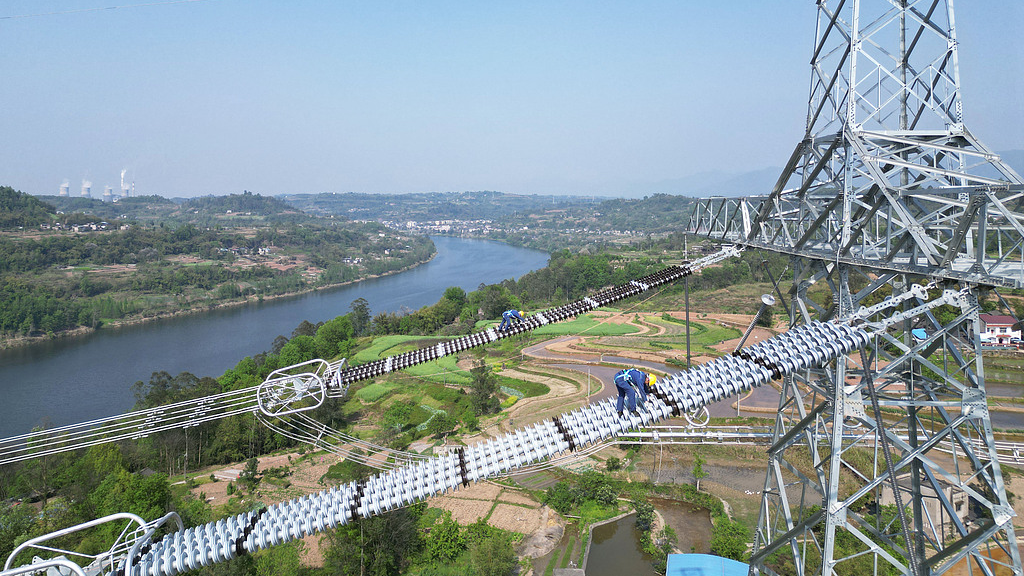Des employés de State Grid inspectent les pylônes de transmission alors que la section de Chongqing du projet de transmission à ultra haute tension de ± 800 kV Hami-Chongqing achève l'inspection de la ligne, municipalité de Chongqing, Chine, le 8 avril 2025. /VCG